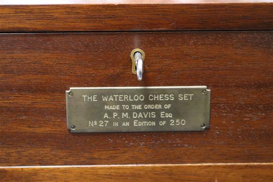 A Waterloo chess set by Charles Stadden, No. 27/250, in military style brass-bound mahogany games table on folding stand